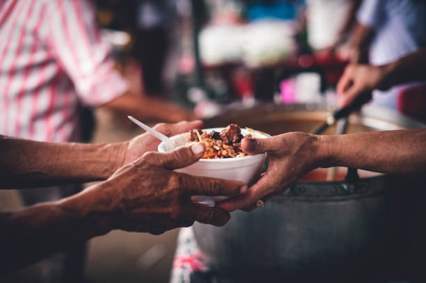 Concept of giving free food to the poor in the community : Volunteers handing out food to hungry people